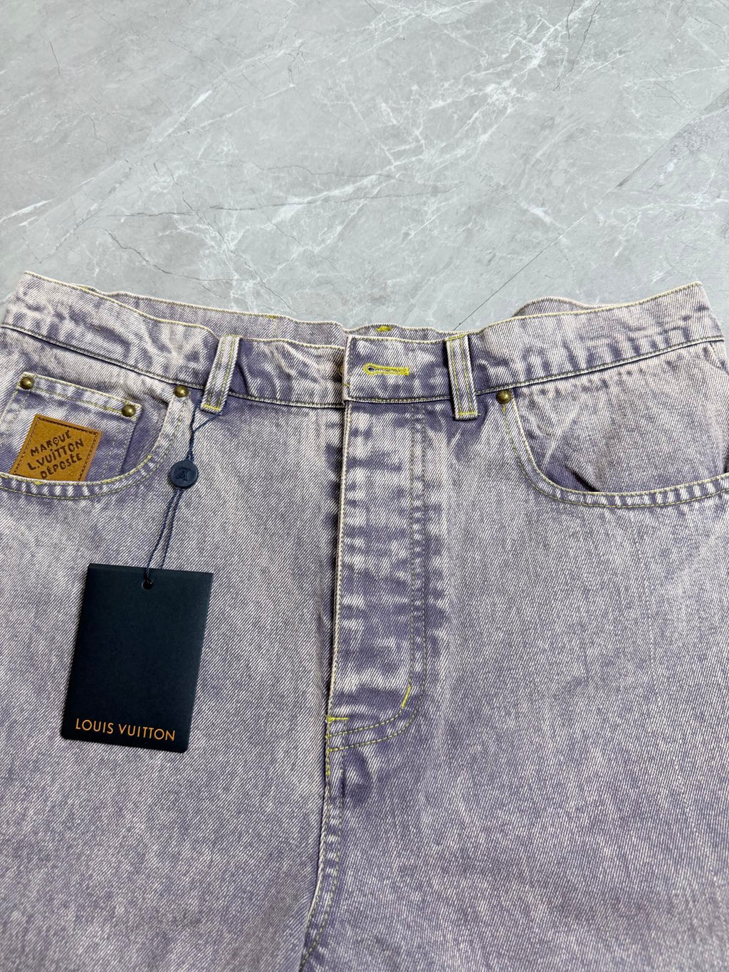 Light-wash Louis Vuitton denim pants with coin pocket and two attached Louis Vuitton hang tags