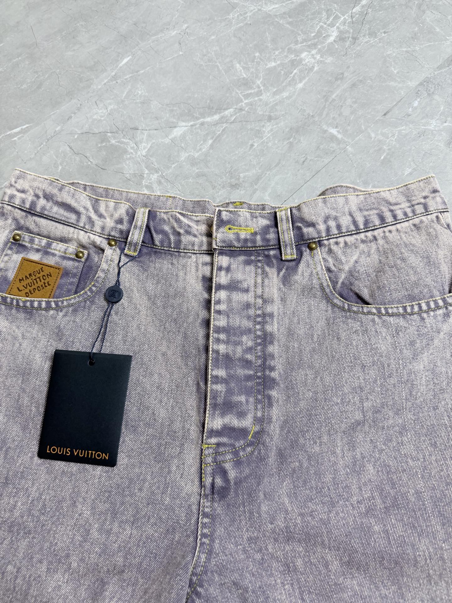 Light-wash Louis Vuitton denim pants with coin pocket and two attached Louis Vuitton hang tags