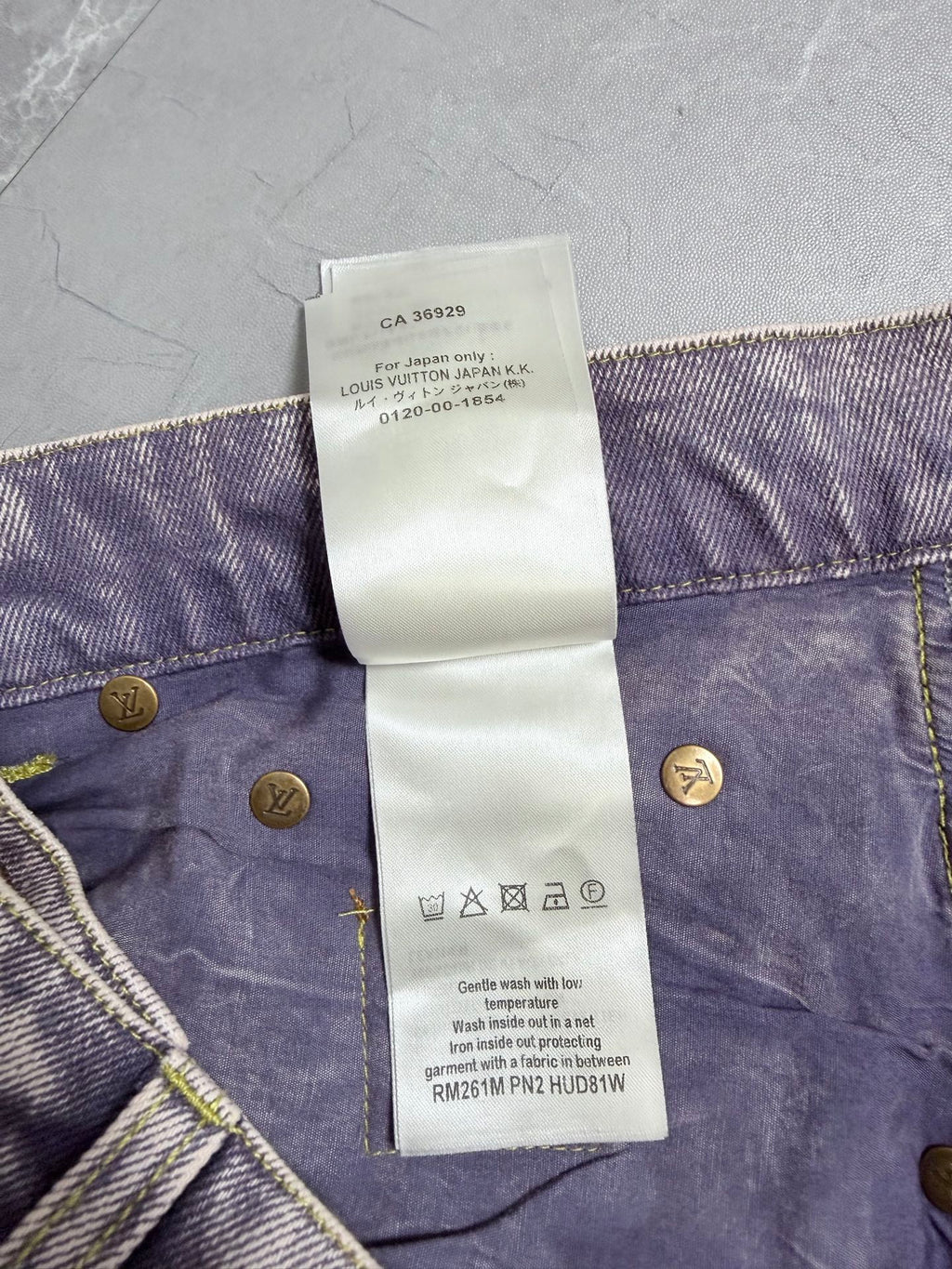 Denim pants waistband care label with country info and gold buttons