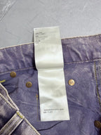 Denim pants waistband with white care label text and gold button