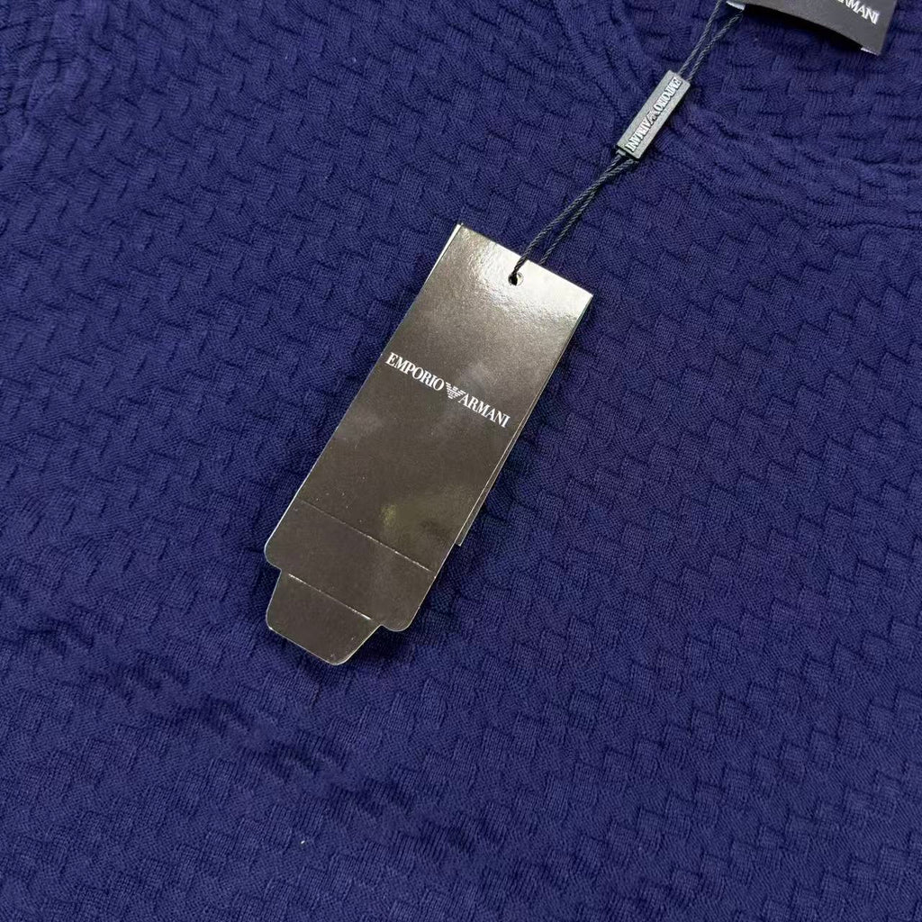 Dark blue textured knit sweater with neck tag and fabric weave detail