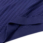 Dark blue knit sweater fabric close-up with ribbed edge at hem