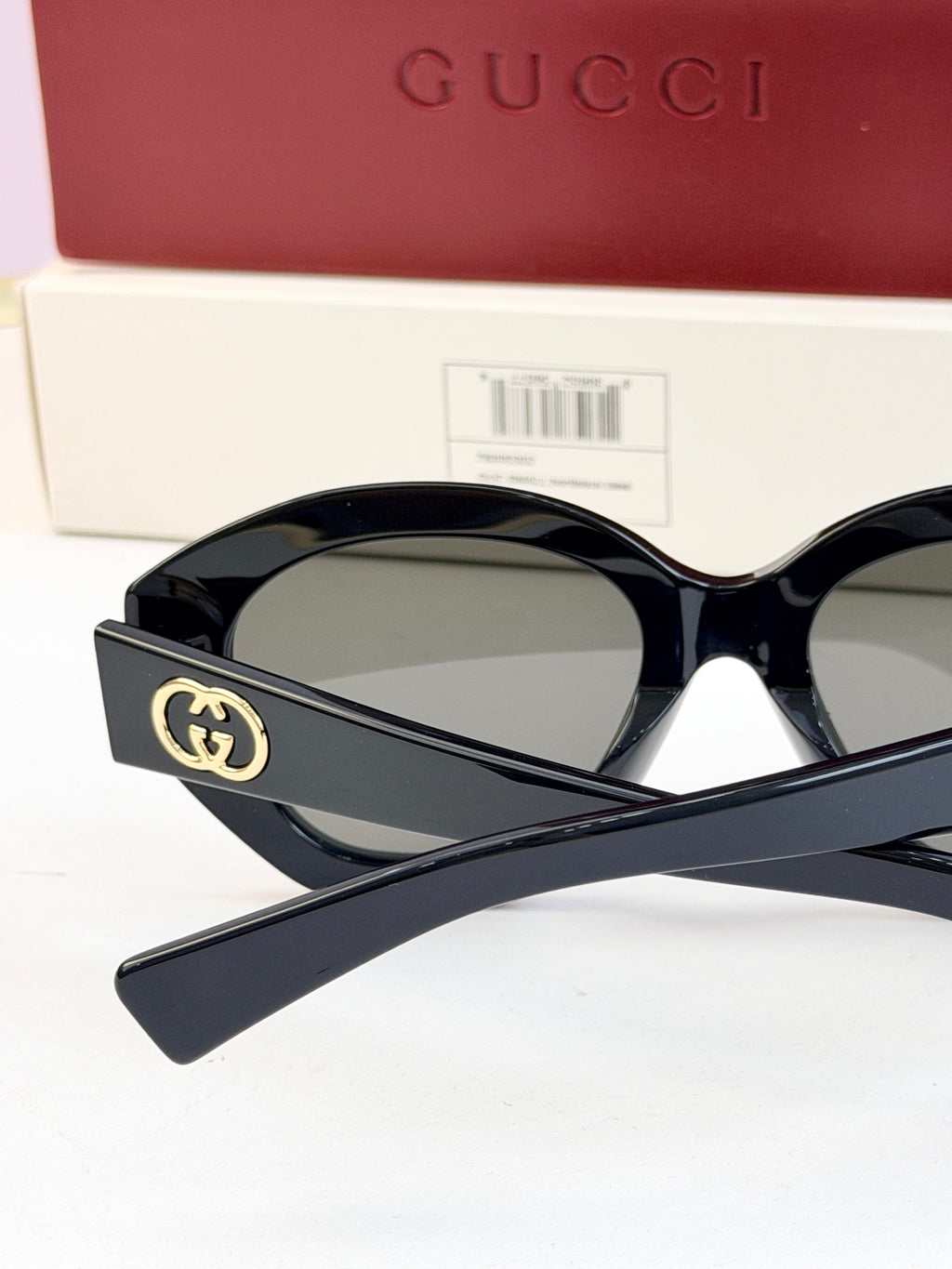 Black sunglasses with gold double-G logo on temple and gray-tinted lenses
