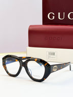 Tortoiseshell round sunglasses with clear lenses and gold double-G logo on temples