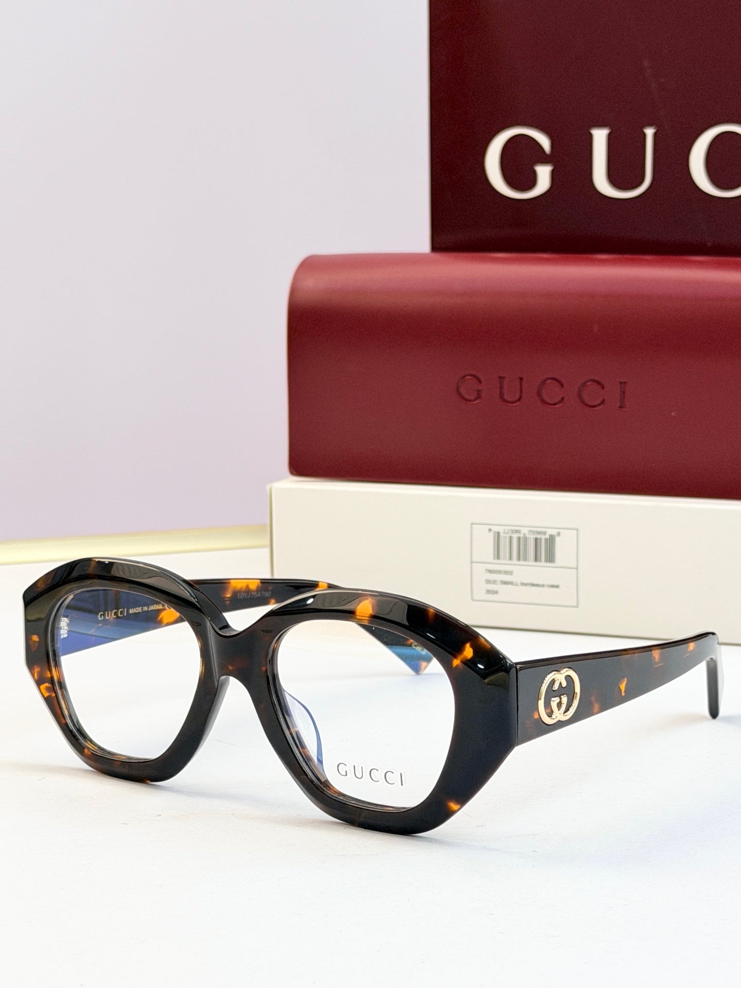 Tortoiseshell round sunglasses with clear lenses and gold double-G logo on temples