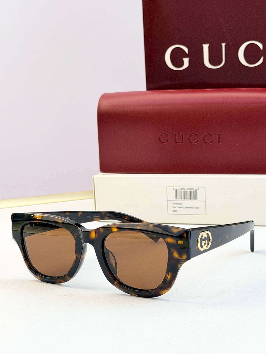 Gucci sunglasses with dark tortoiseshell acetate frames and brown-tinted lenses, gold logo