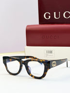 Gucci optical glasses with dark tortoiseshell acetate frames and clear lenses, gold logo