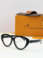 Black oval sunglasses with dark lenses and gold-tone arms, shown front