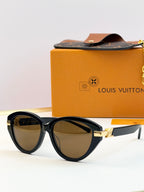 Dark frames oval sunglasses with brown-tinted lenses and gold-tone hinge detail