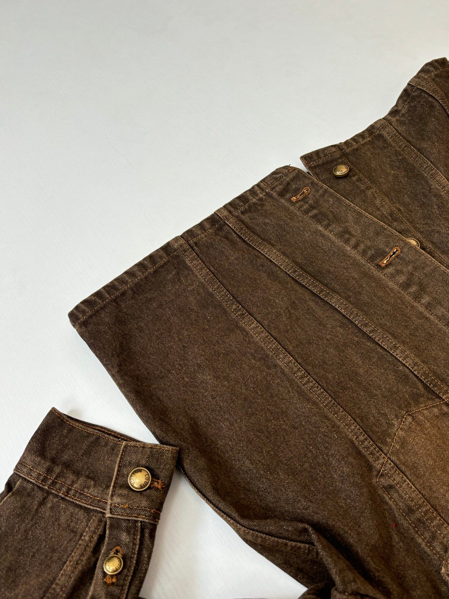 Louis Vuitton brown denim jacket close-up of side seams and chest pocket buttons