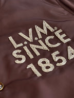 Louis Vuitton long bomber jacket chest rhinestone lettering on dark brown fabric