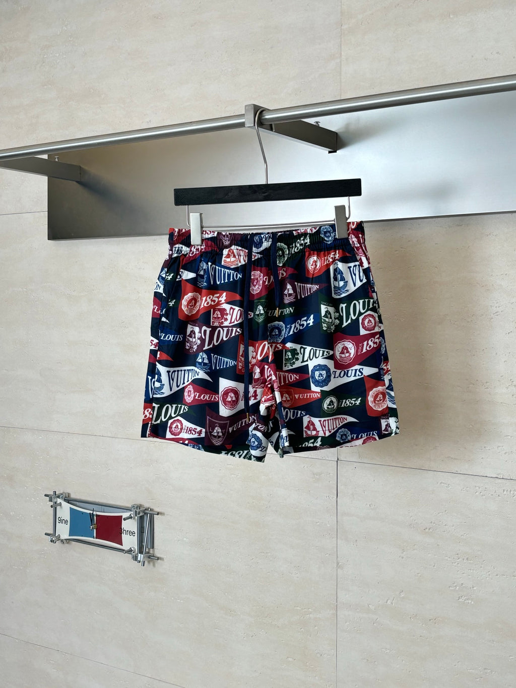 Louis Vuitton logo-print shorts on hanger, navy red and white multicolor pattern