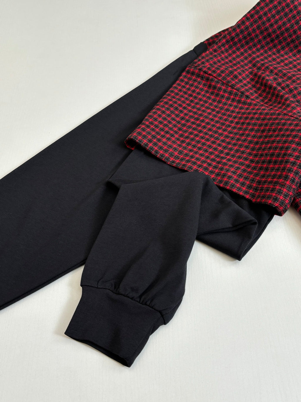 Balenciaga long-sleeve shirt cuff detail; black sleeve with red check shoulder