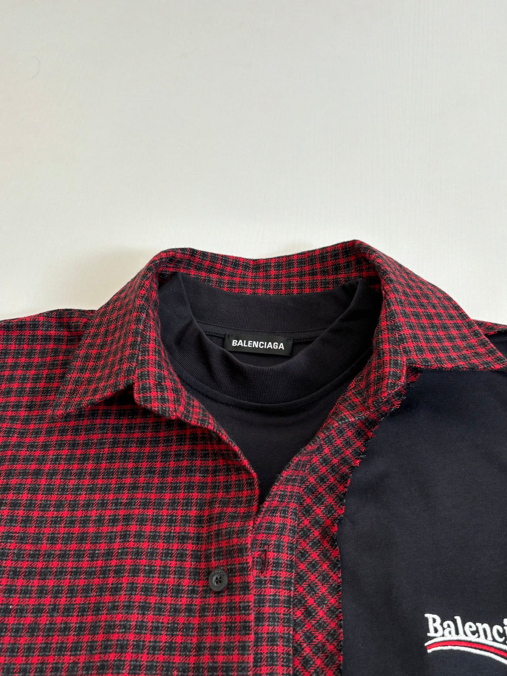 Balenciaga long-sleeve shirt collar closeup; red-and-black check with black placket
