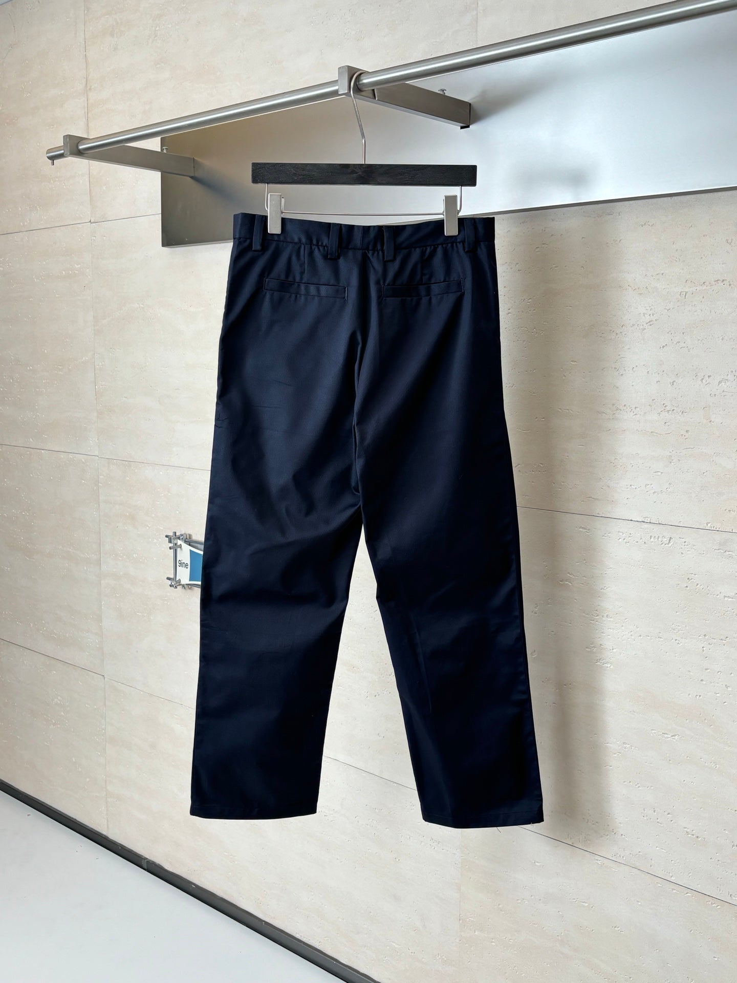 Gucci navy pants hanging on a hanger, straight leg with front crease