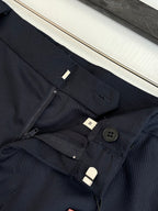 Gucci navy pants waistband close-up with zipper, button, and belt loops