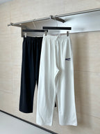 Pair of drawstring pants: black and white, both with elastic waistband