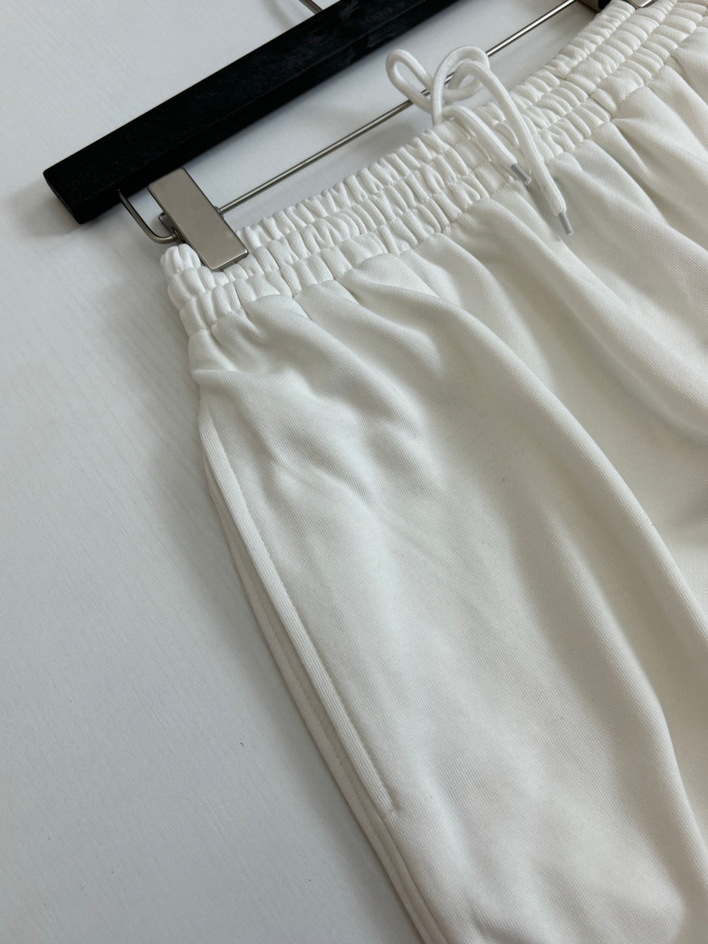 White drawstring pants with gathered elastic waistband
