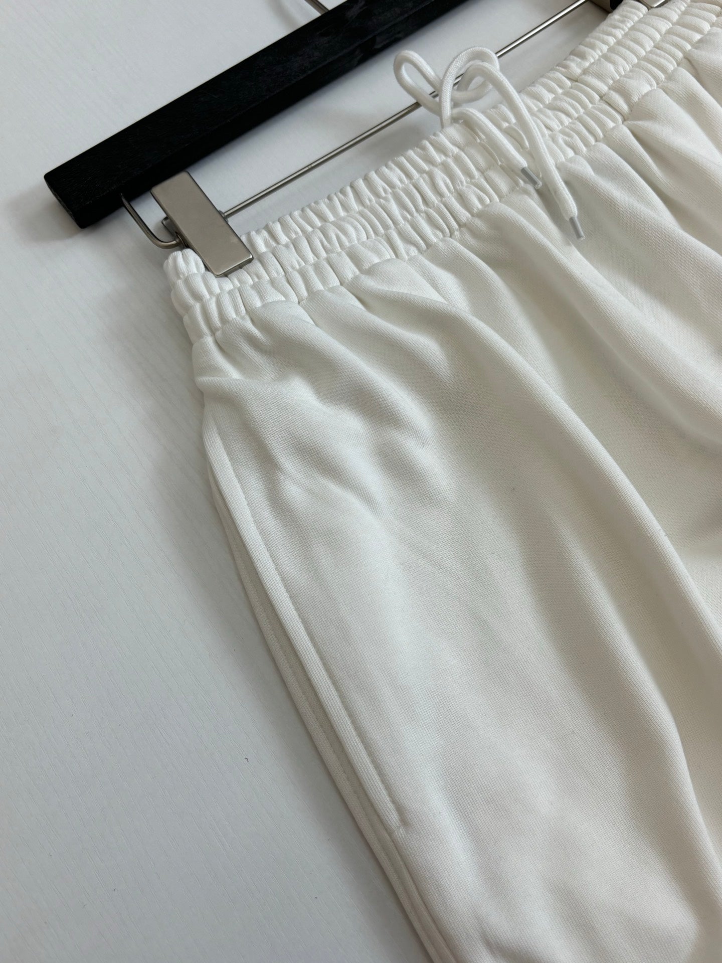 White drawstring pants with gathered elastic waistband