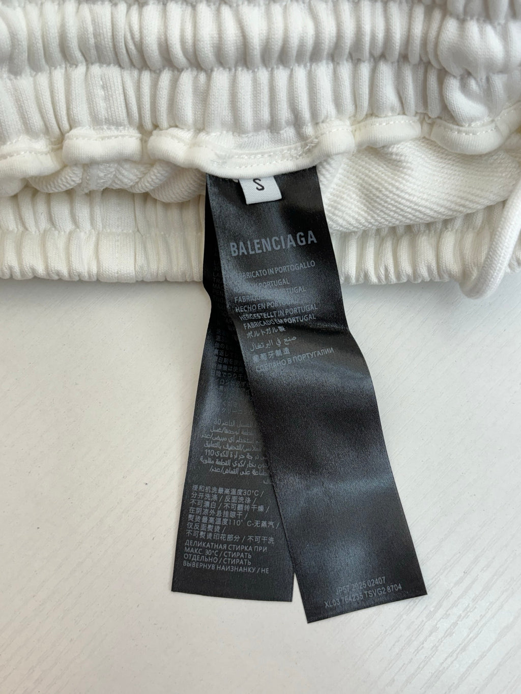 White pants size tag and care label on elastic waistband