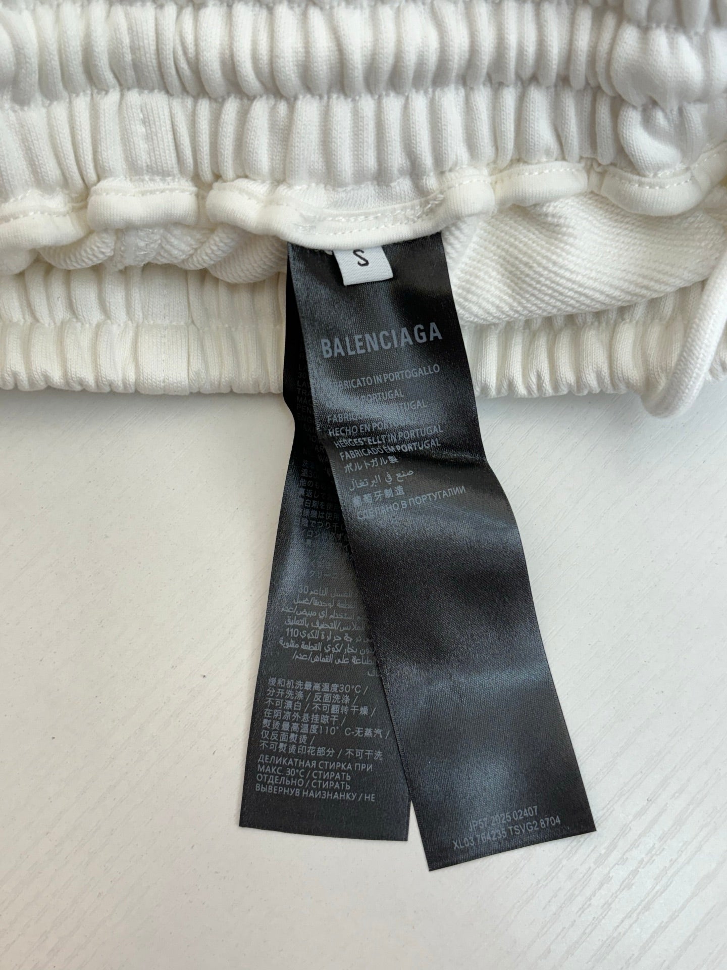 White pants size tag and care label on elastic waistband