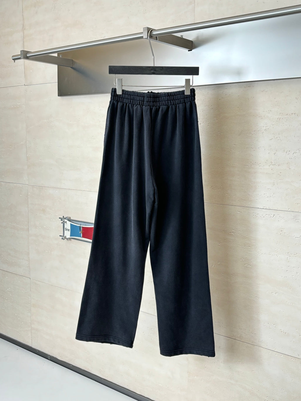Black Balenciaga track pants on hanger, drawstring waist and wide legs