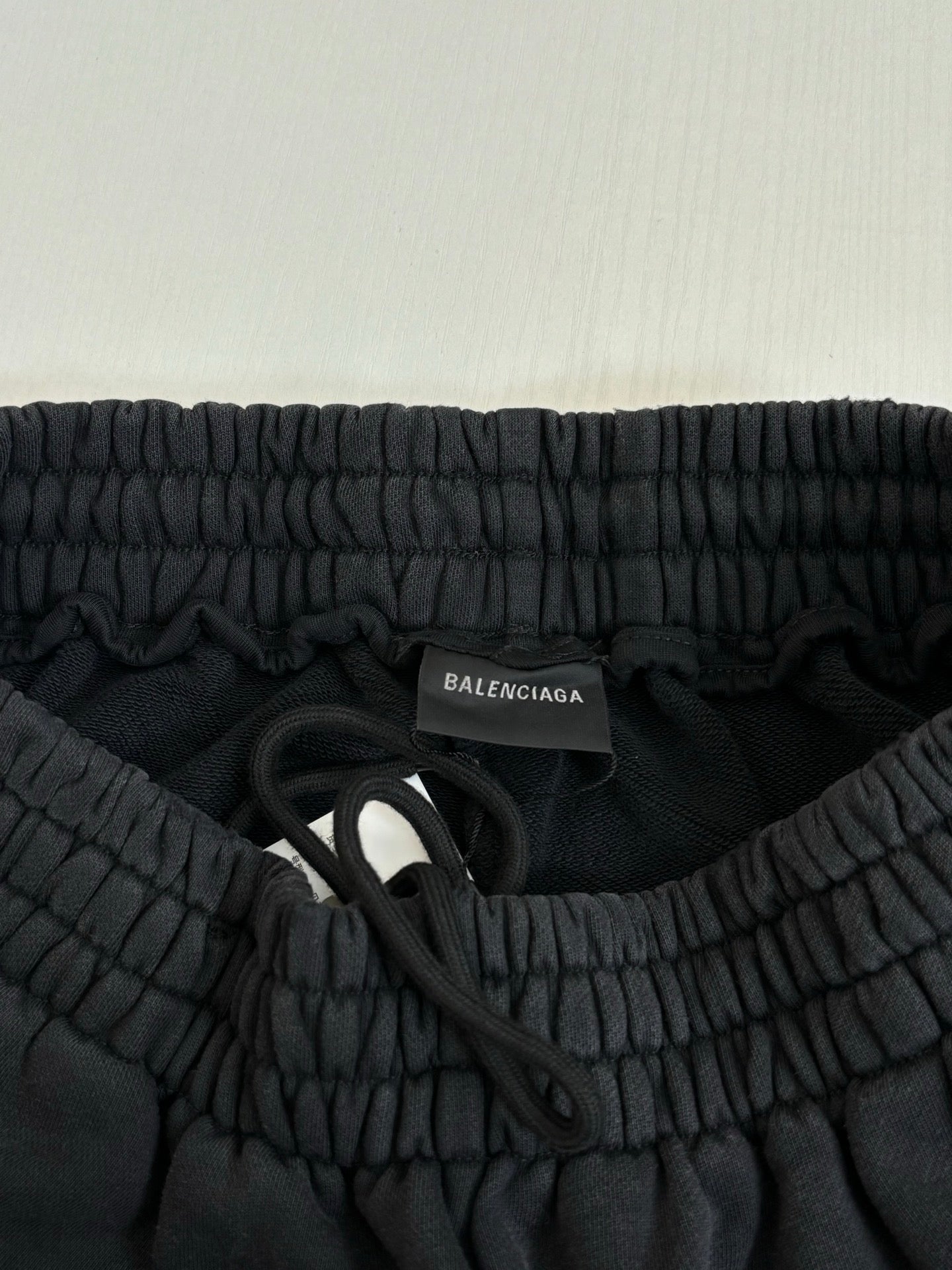 Black Balenciaga pants waistband with inner neck label and fabric ruching