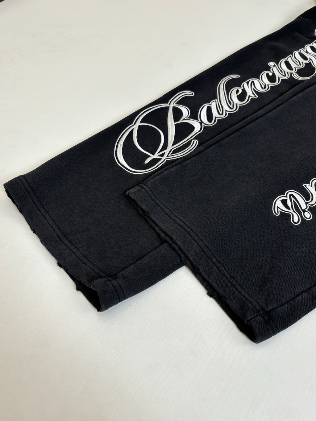 Black Balenciaga track pants with white script logo on waistband and cuff