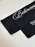 Black Balenciaga track pants with white script logo on waistband and cuff