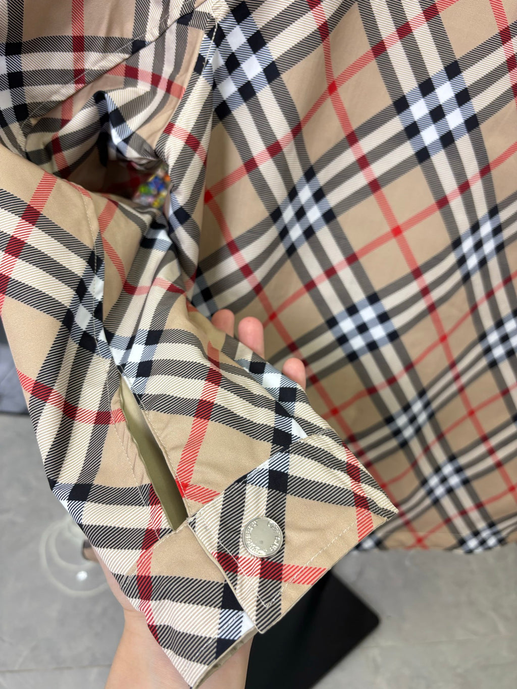 Beige jacket hood lining with Burberry plaid check pattern and snap button