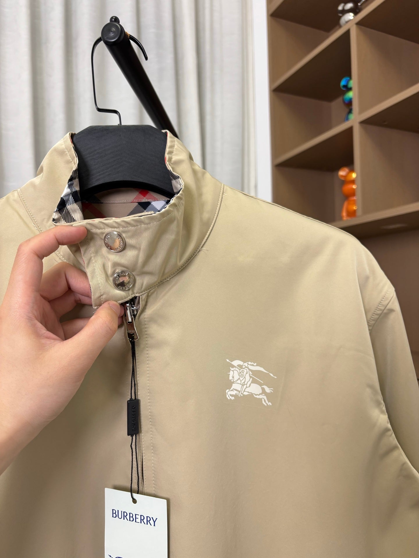 Beige Burberry long jacket with front zipper and horse logo on chest