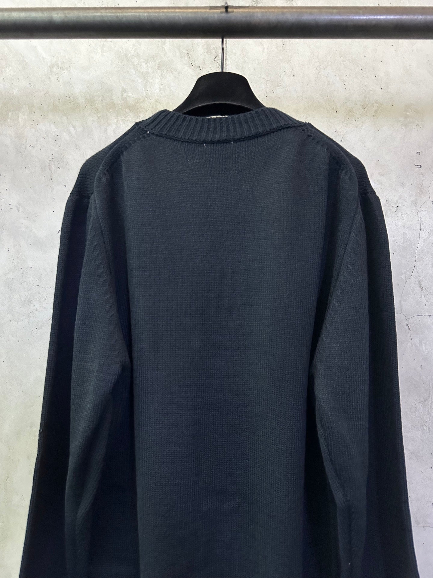 Dark navy knit sweater, crew neckline and ribbed cuffs, back view