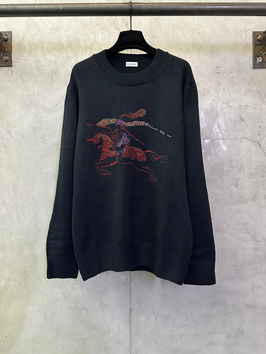 Dark navy knit sweater with colorful racing horse graphic on the front