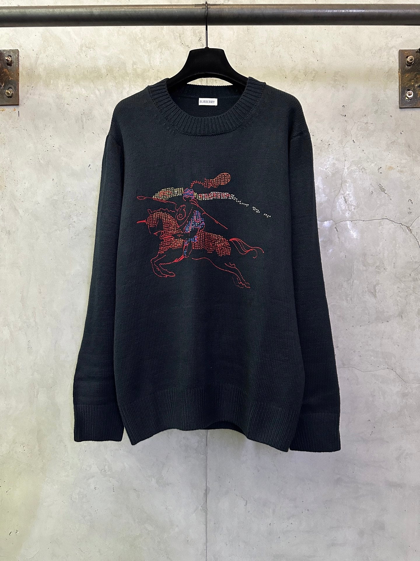 Dark navy knit sweater with colorful racing horse graphic on the front