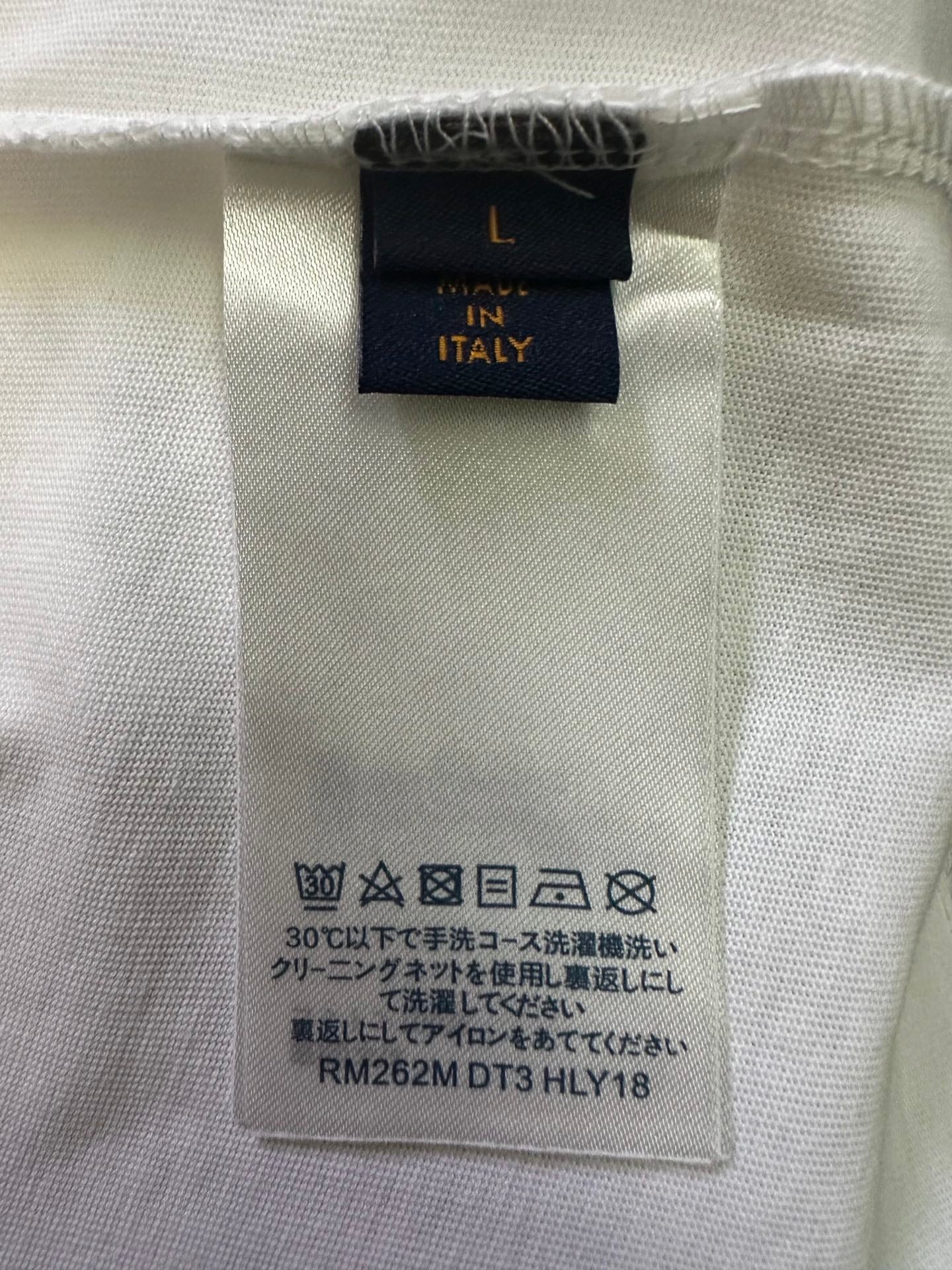Inside care label and size tag on white T-shirt fabric