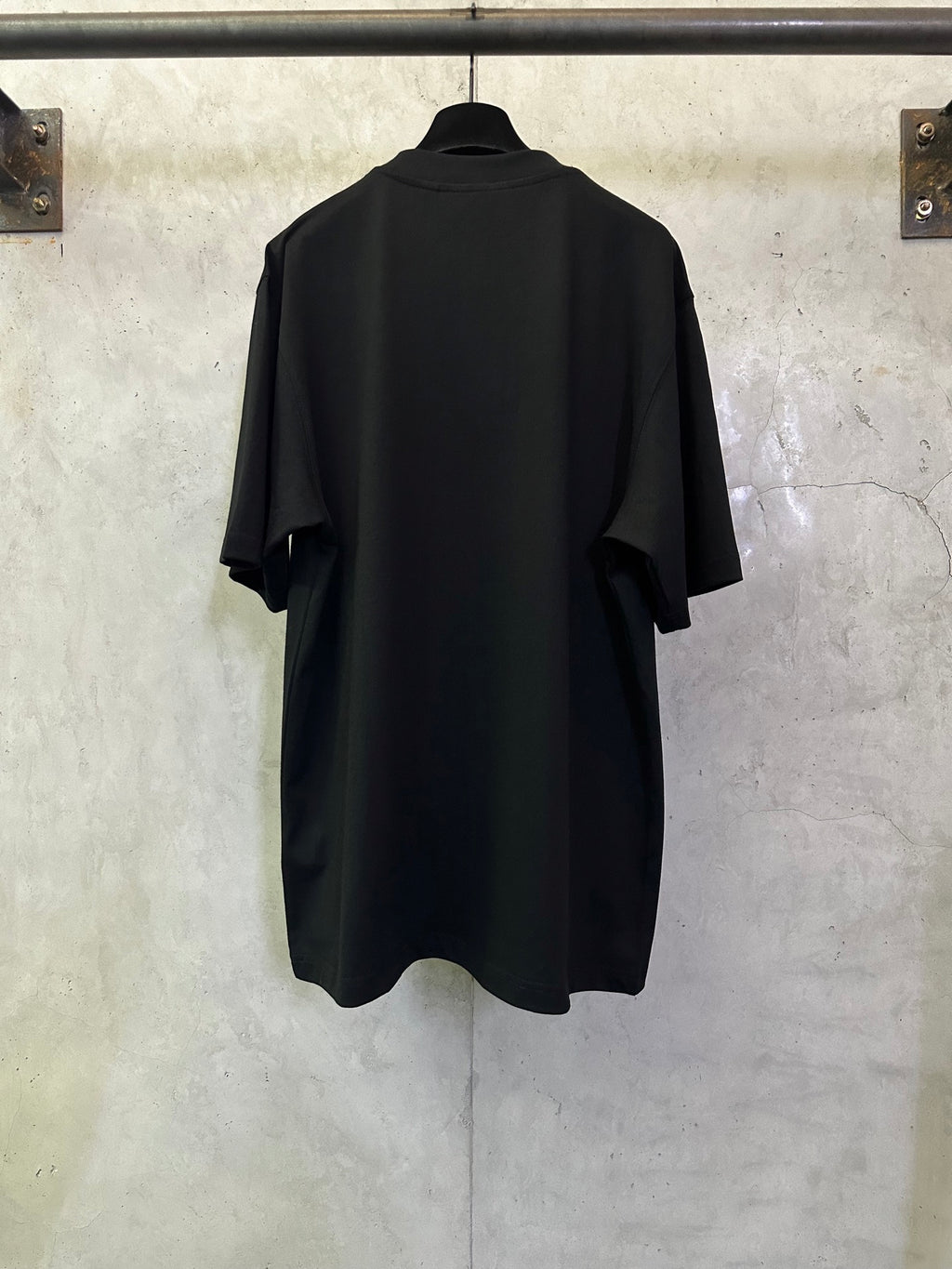 Black crewneck short-sleeve T-shirt, back view with curved hem