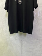 Black crewneck short-sleeve T-shirt, lower front with partial logo