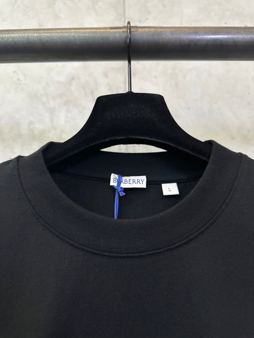 Black crewneck T-shirt neckline with Burberry size tag inside collar