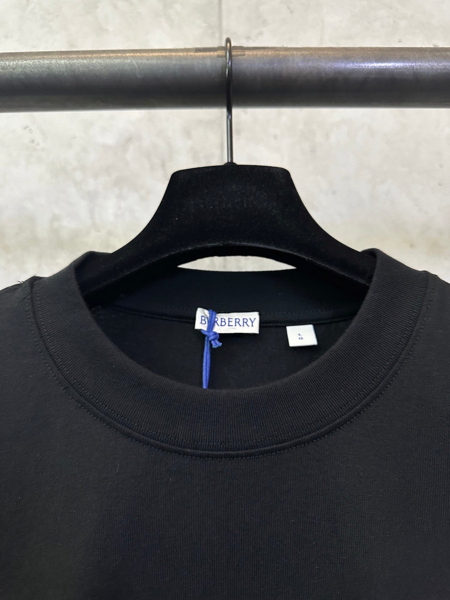 Black crewneck T-shirt neckline with Burberry size tag inside collar