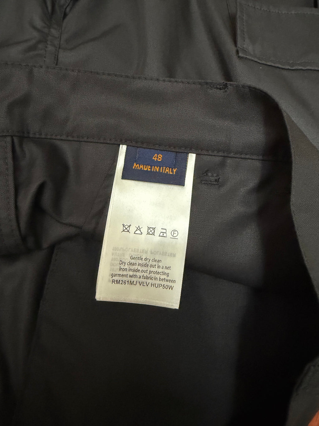 Size label inside black cargo shorts with care instructions and manufacturing info