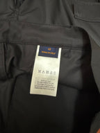 Size label inside black cargo shorts with care instructions and manufacturing info
