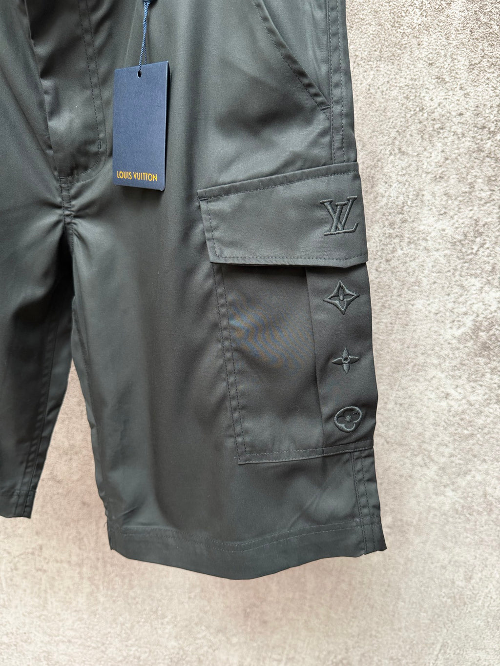 Cargo shorts pocket close-up with Louis Vuitton logo and star appliques