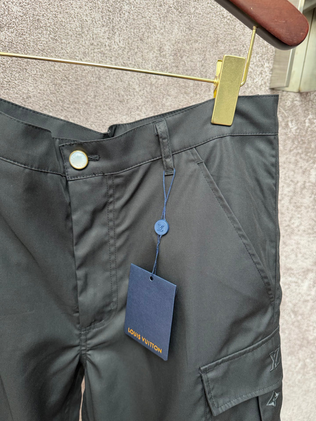 Black cargo shorts waist with button and hanging tag, front cargo pocket