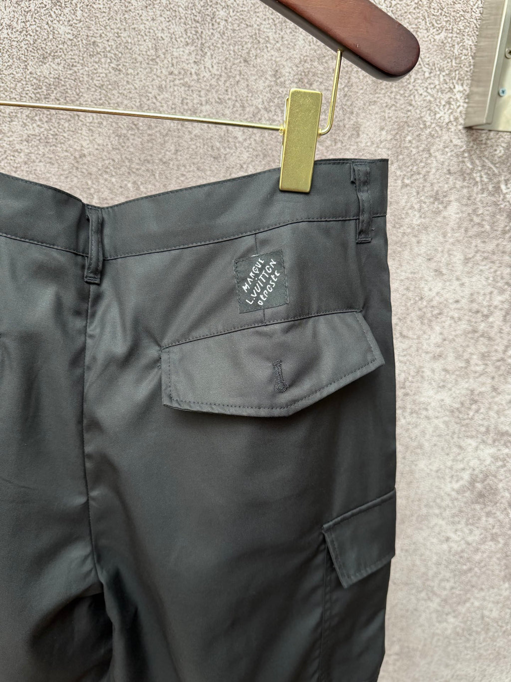 Black cargo shorts rear with flap pocket and small Louis Vuitton logo patch