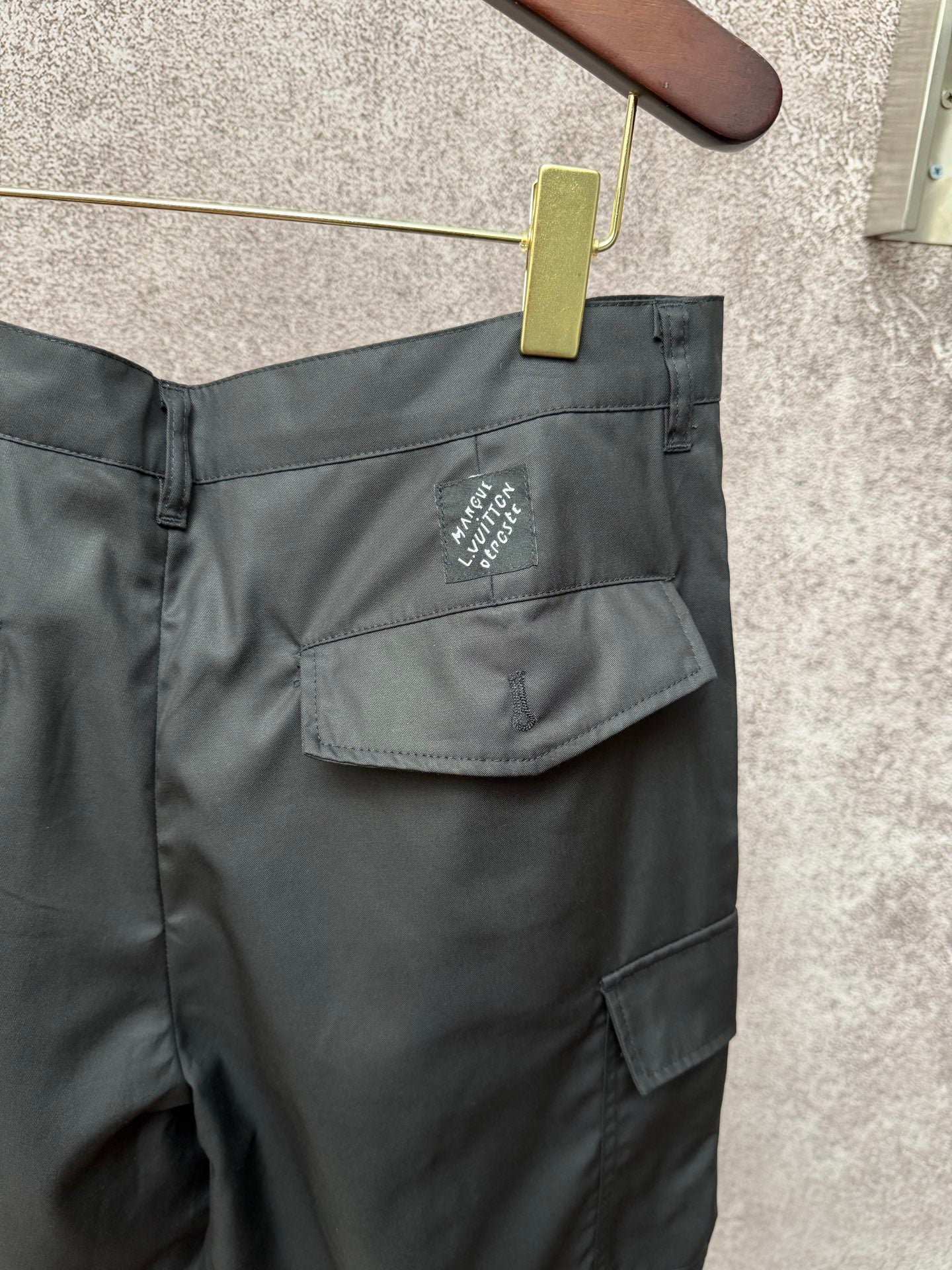 Black cargo shorts rear with flap pocket and small Louis Vuitton logo patch