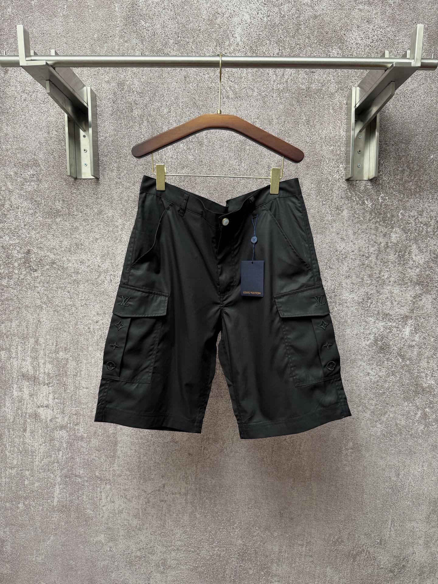 Black cargo shorts with cargo pockets and Louis Vuitton logo patch