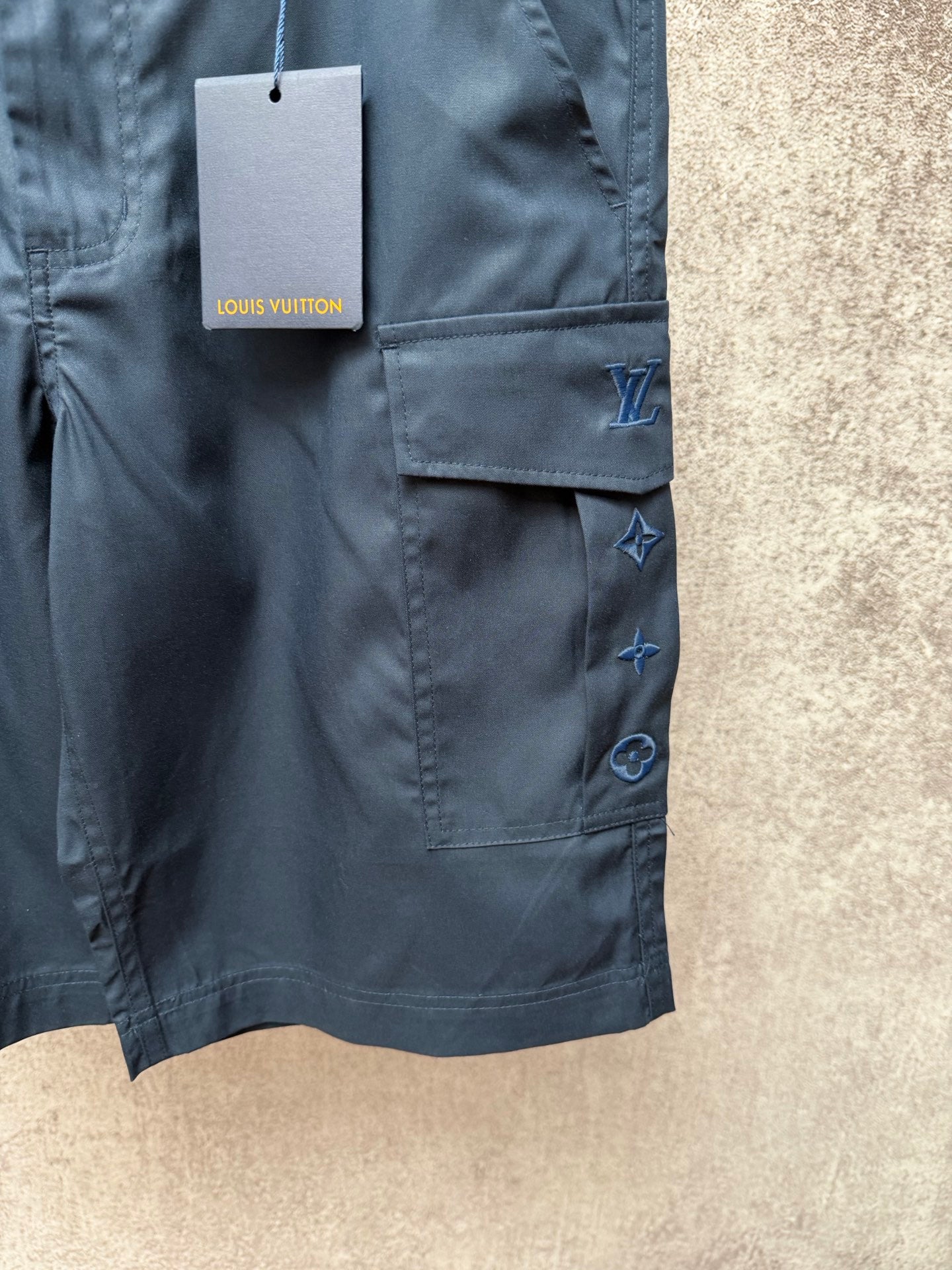 Dark blue cargo shorts with patch pocket, belt loops, and Louis Vuitton hang tag