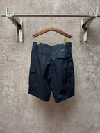 Dark blue cargo shorts with back pockets and belt loops, hanging on a hanger