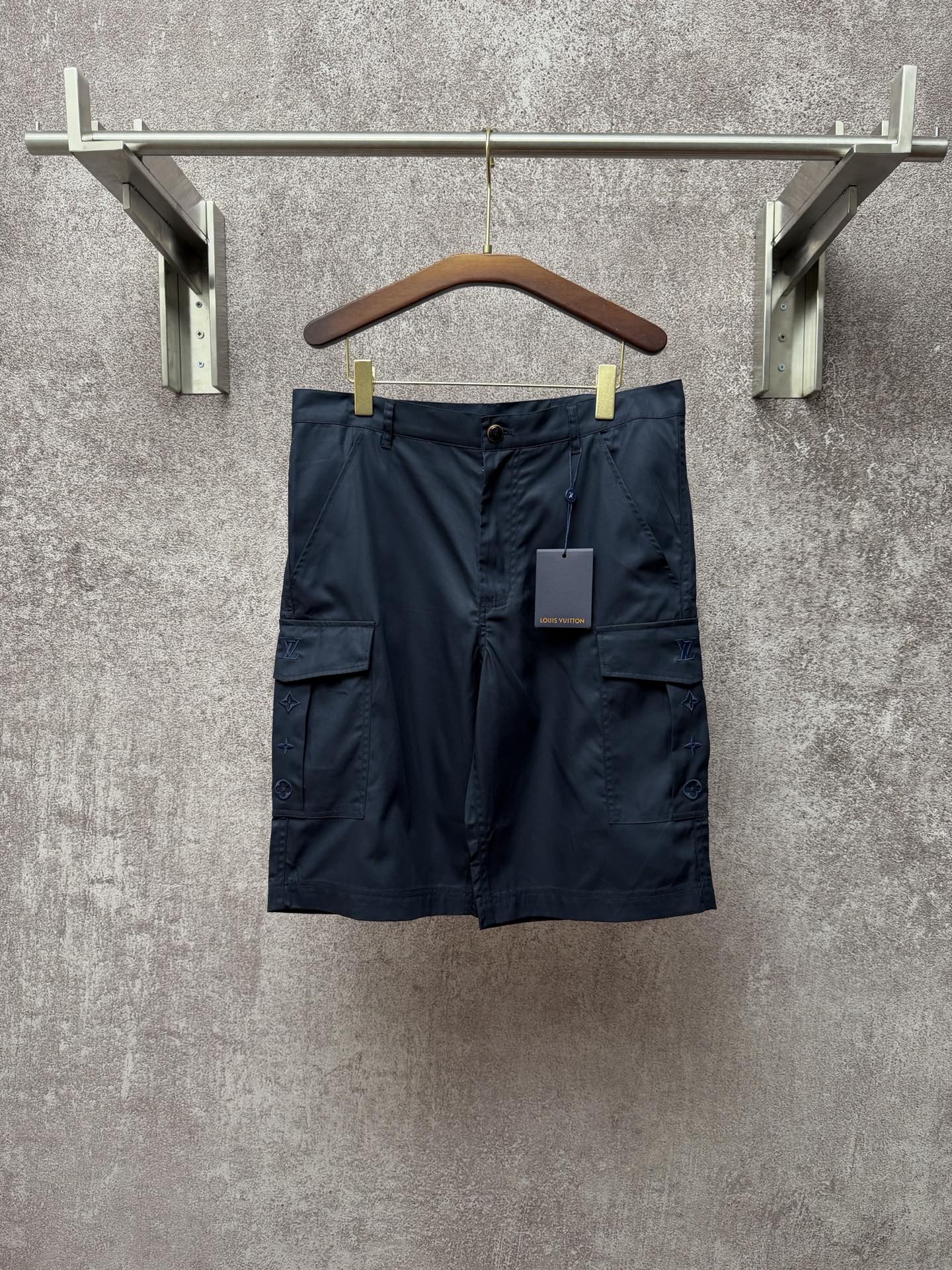 Dark blue cargo shorts with front zipper, belt loops, and two flap side pockets