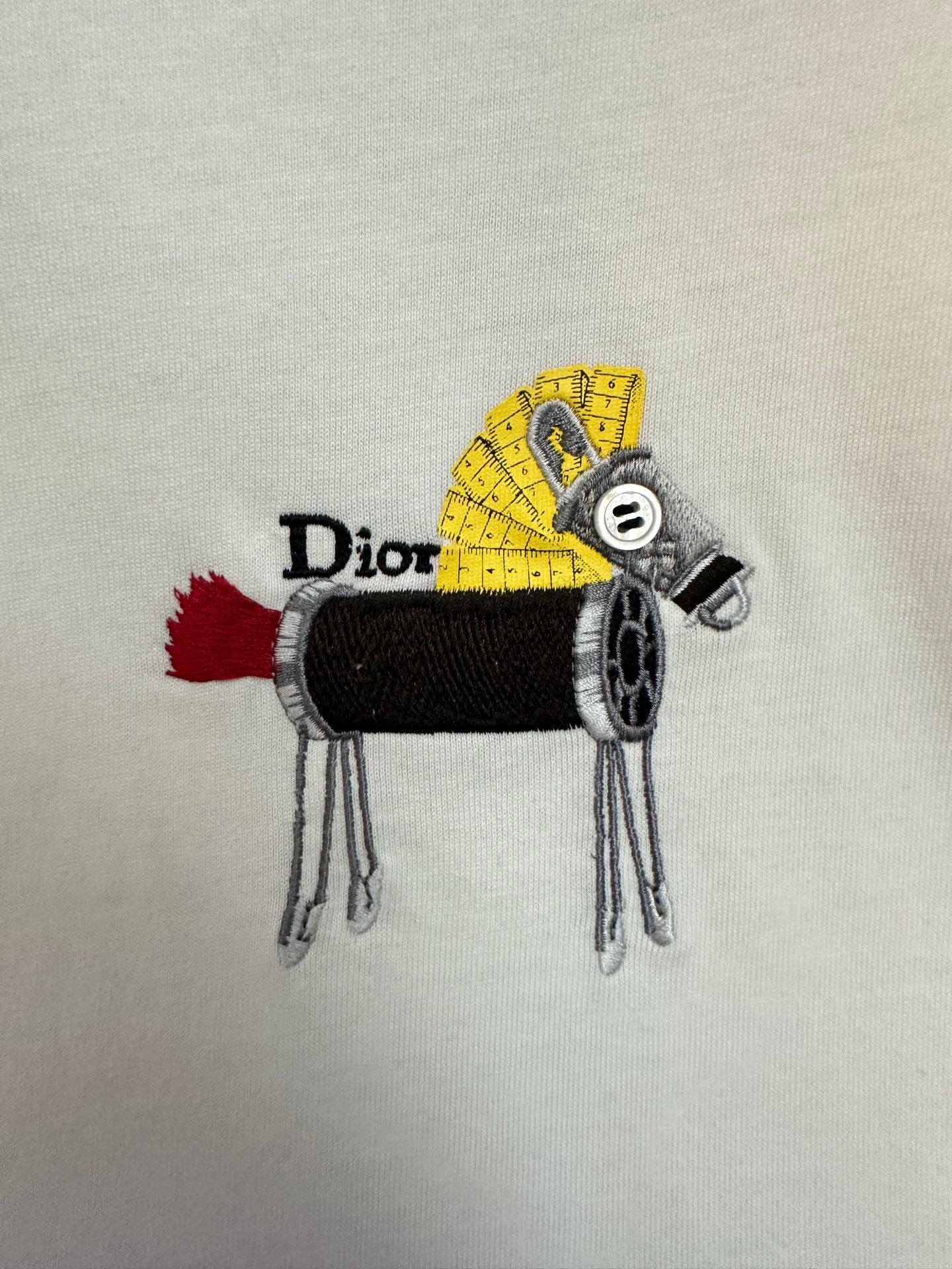 Embroidered Dior graphic on white T-shirt: black and yellow character